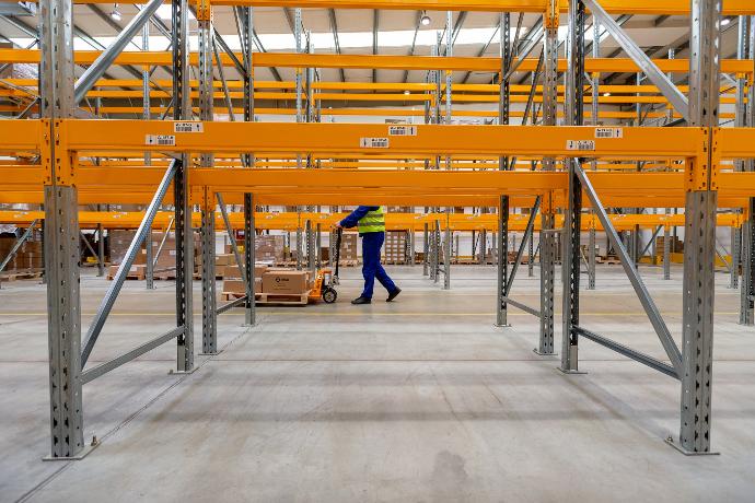 person in blue jacket walking on gray concrete floor